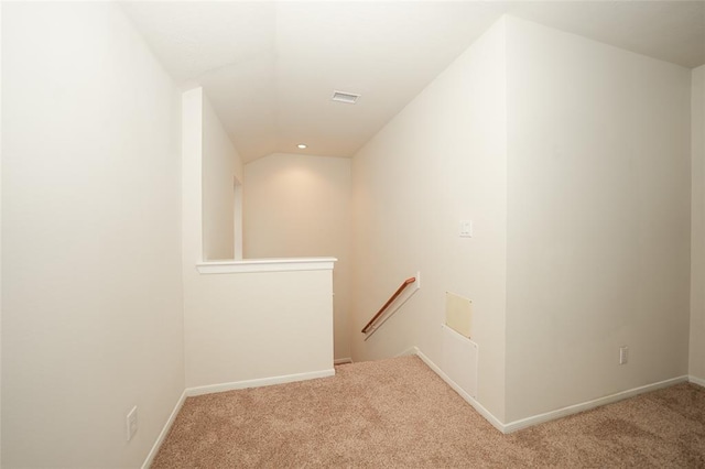 staircase featuring carpet floors and lofted ceiling