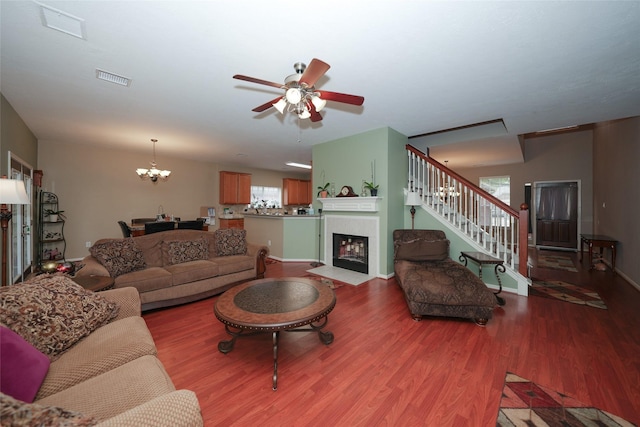 living room featuring hardwood / wood-style floors and ceiling fan with notable chandelier