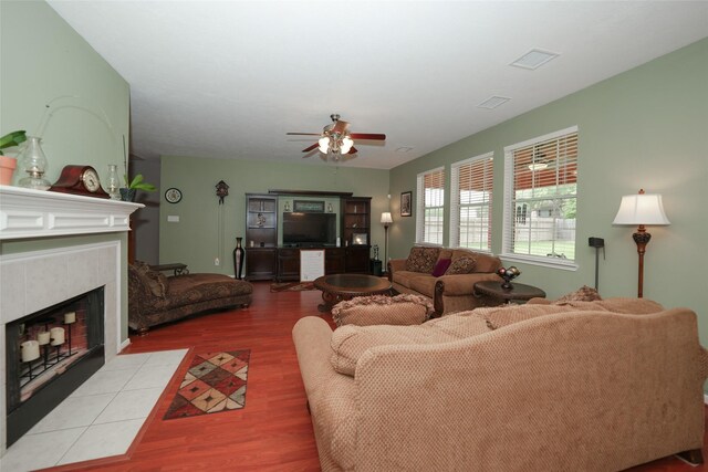 living room with ceiling fan and a fireplace