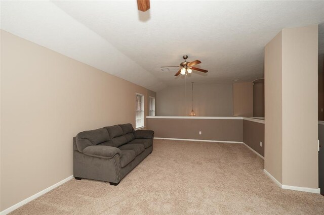 living area with ceiling fan, light colored carpet, and vaulted ceiling