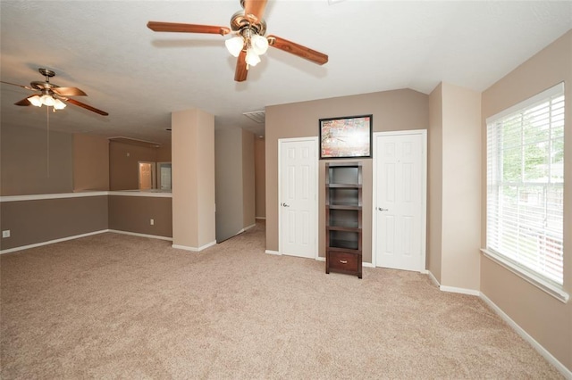 unfurnished bedroom with light carpet, ceiling fan, and lofted ceiling