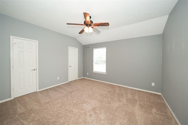 carpeted spare room with ceiling fan and lofted ceiling