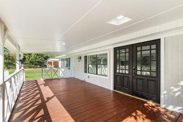 wooden deck featuring a lawn and french doors