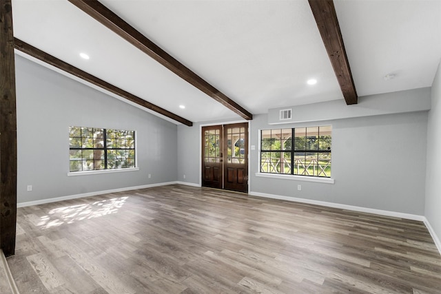 unfurnished living room featuring wood-type flooring, french doors, and a healthy amount of sunlight