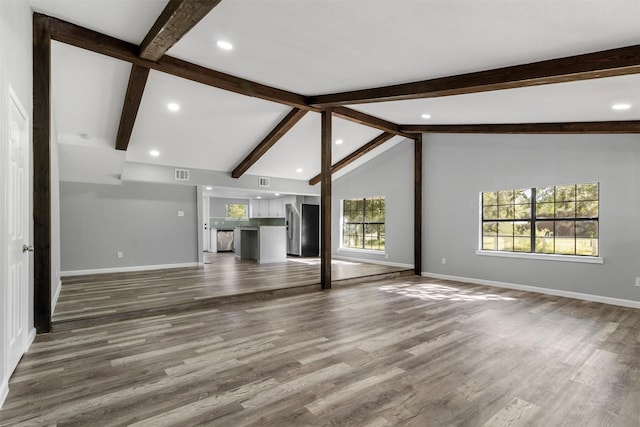 unfurnished living room with vaulted ceiling with beams and hardwood / wood-style flooring