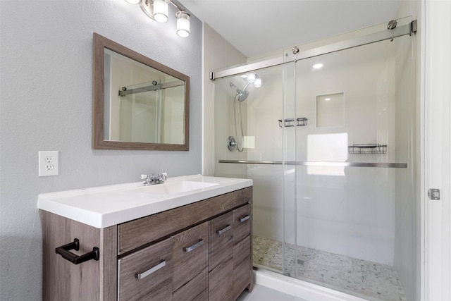 bathroom featuring vanity and a shower with shower door