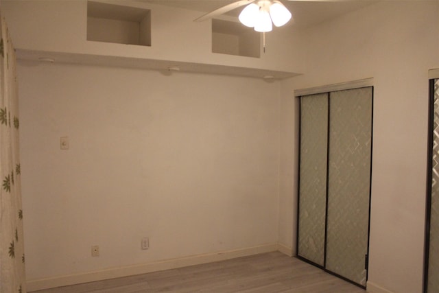 unfurnished bedroom with ceiling fan, a closet, and light wood-type flooring