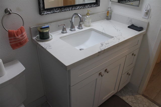 bathroom with tile patterned floors, vanity, and toilet