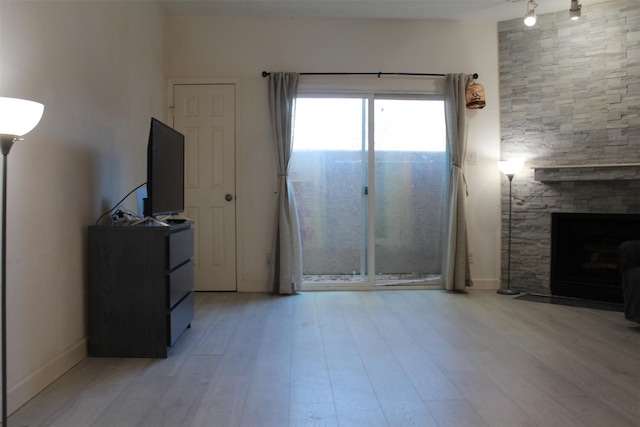 unfurnished living room with a fireplace and light hardwood / wood-style floors