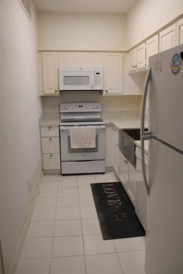 kitchen featuring white cabinets, white appliances, and light tile patterned floors