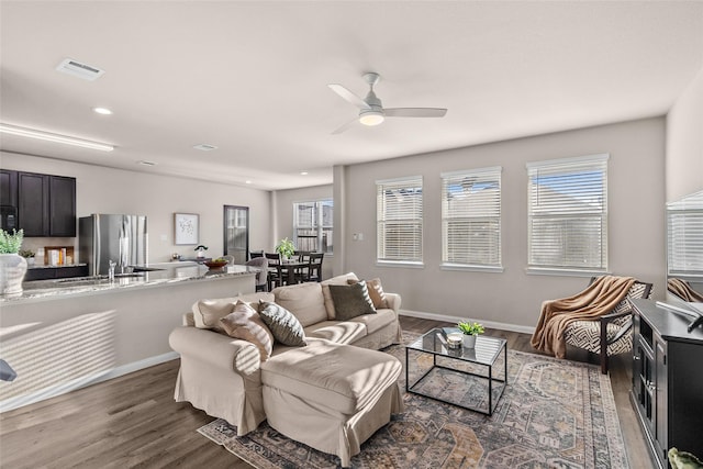 living room with ceiling fan, sink, and dark hardwood / wood-style floors