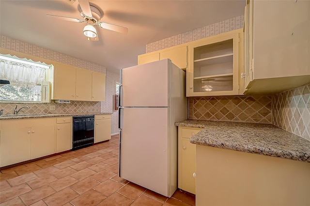 kitchen with light stone counters, ceiling fan, sink, dishwasher, and white fridge