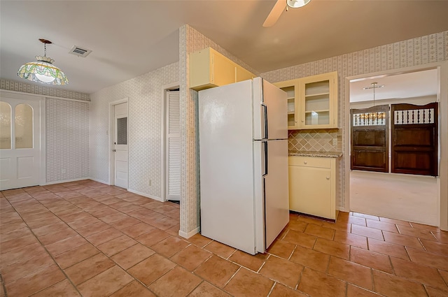 kitchen featuring ceiling fan, white fridge, pendant lighting, and light tile patterned floors