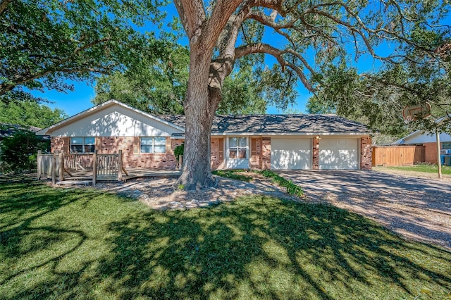 ranch-style house featuring a garage, a deck, and a front lawn