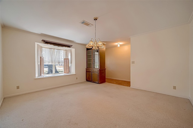 carpeted empty room featuring ornamental molding and a notable chandelier