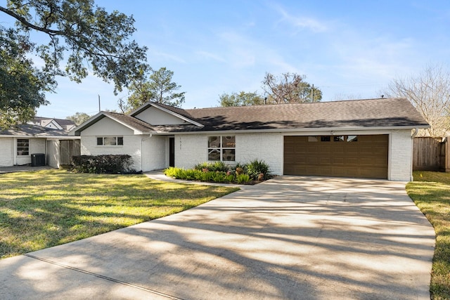 ranch-style home with a front lawn, central AC unit, and a garage