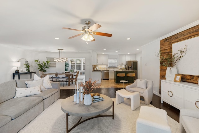 living room featuring ceiling fan, wood-type flooring, and ornamental molding