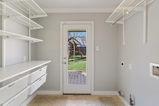 interior space with electric dryer hookup, crown molding, light tile patterned floors, and washer hookup