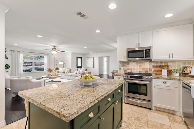 kitchen with green cabinets, a center island, white cabinets, and stainless steel appliances