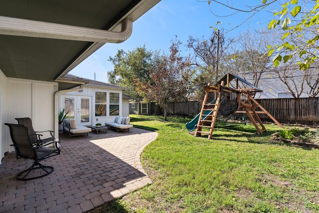 view of yard featuring a playground, french doors, and a patio