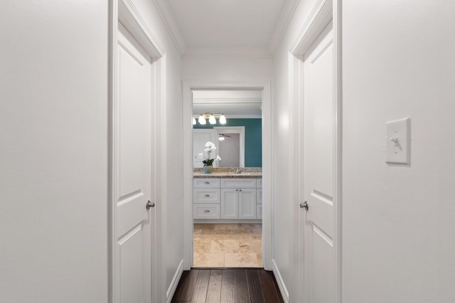 corridor featuring dark hardwood / wood-style flooring, ornamental molding, and sink