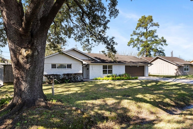 ranch-style home with a garage and a front lawn