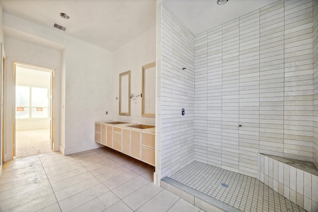 bathroom featuring tiled shower, vanity, and tile patterned floors