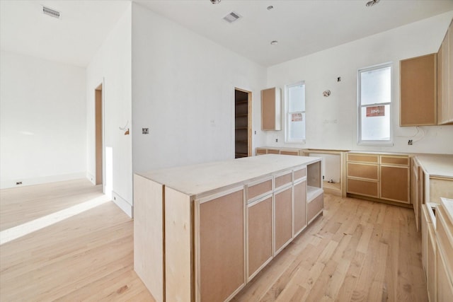 kitchen with a center island, light wood-type flooring, and light brown cabinets