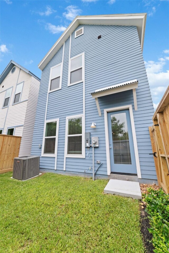 back of house featuring a yard and central AC unit