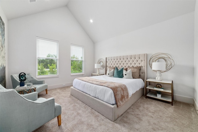 carpeted bedroom with high vaulted ceiling