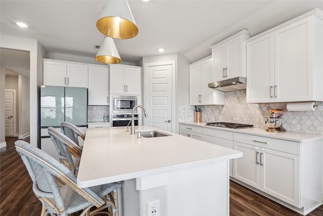 kitchen featuring white cabinetry, sink, hanging light fixtures, and stainless steel appliances