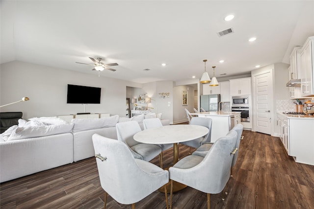 dining area featuring dark hardwood / wood-style floors, vaulted ceiling, ceiling fan, and sink