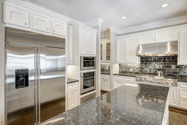 kitchen featuring dark stone countertops, appliances with stainless steel finishes, and white cabinets