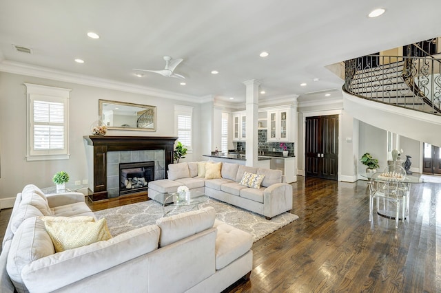 living room featuring crown molding, a fireplace, and a healthy amount of sunlight