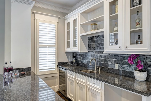 kitchen with sink, wine cooler, white cabinets, and dark stone counters