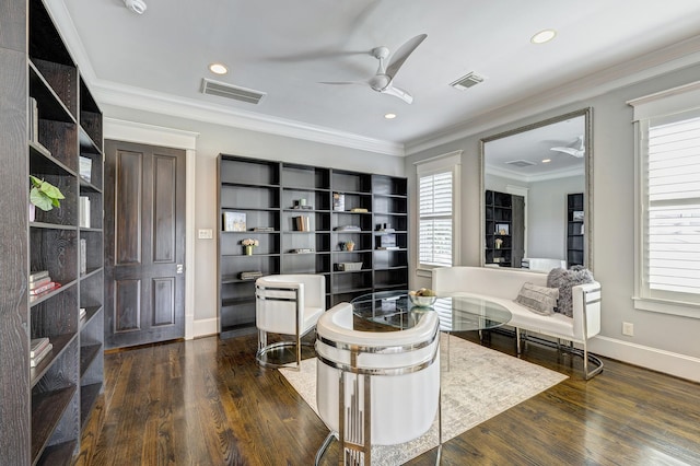 living area with dark wood-type flooring, ceiling fan, and ornamental molding