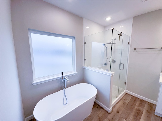 bathroom with plus walk in shower and wood-type flooring