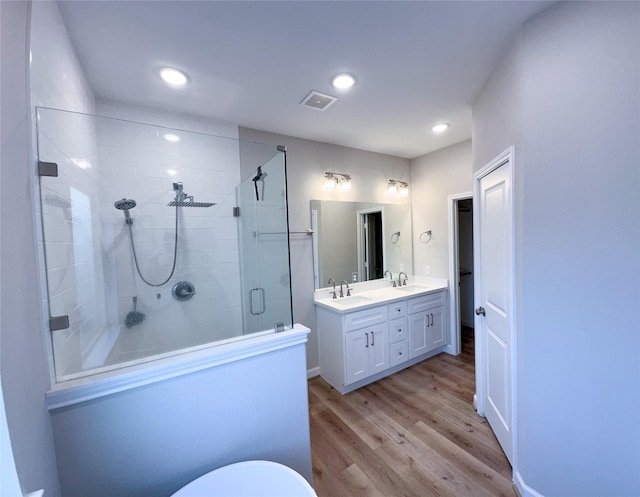 bathroom featuring hardwood / wood-style floors, vanity, and a shower with shower door