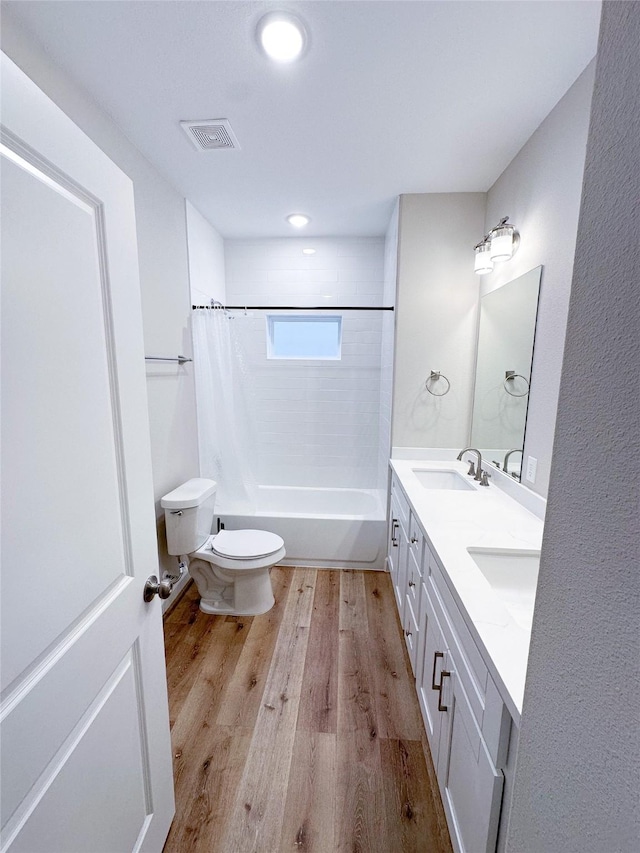 full bathroom with hardwood / wood-style floors, shower / bath combo, toilet, and vanity