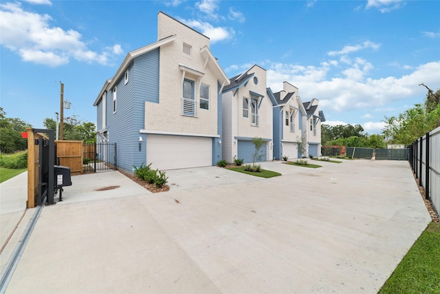 view of front facade featuring a gate, fence, a garage, a residential view, and driveway