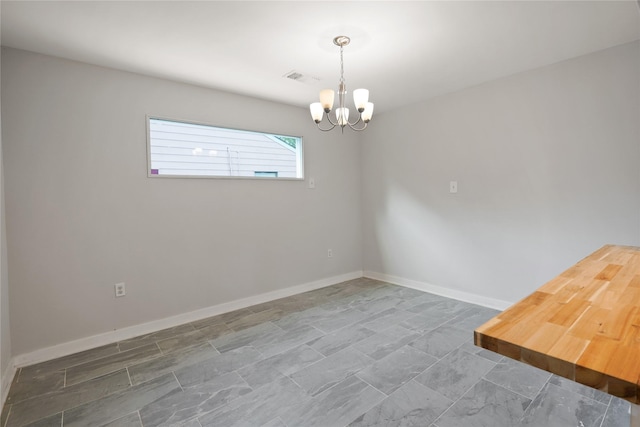 spare room featuring a notable chandelier