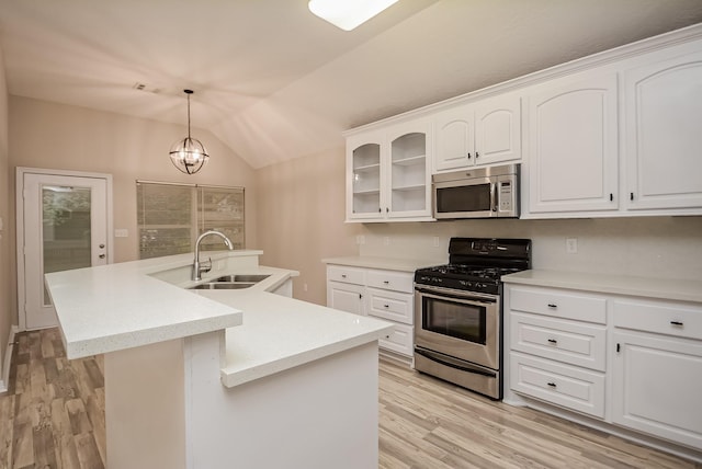 kitchen featuring a kitchen island with sink, hanging light fixtures, sink, appliances with stainless steel finishes, and white cabinetry