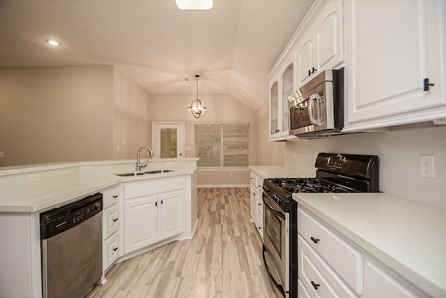 kitchen with sink, stainless steel appliances, an inviting chandelier, pendant lighting, and white cabinets