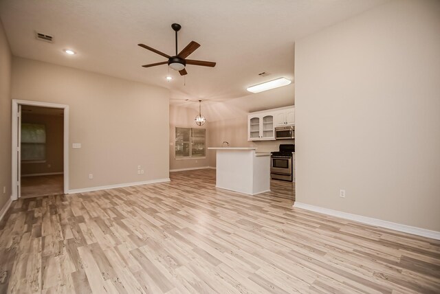 unfurnished living room featuring light hardwood / wood-style floors and ceiling fan with notable chandelier