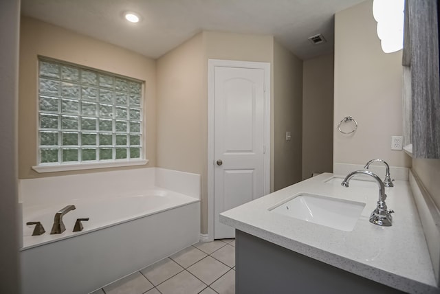 bathroom featuring tile patterned flooring, vanity, and a washtub