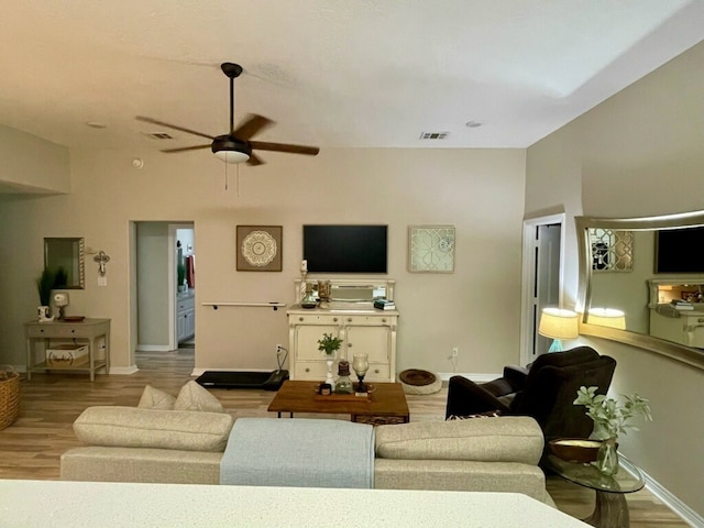 living room with ceiling fan and light hardwood / wood-style flooring