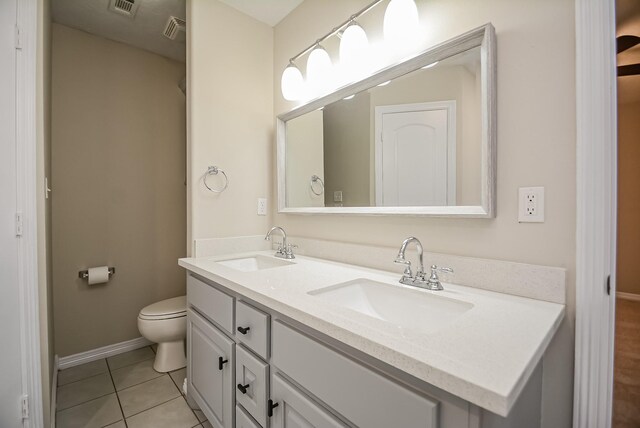 bathroom with tile patterned flooring, vanity, and toilet