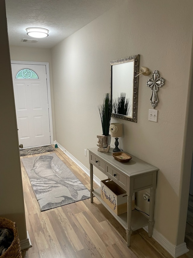 foyer with light hardwood / wood-style floors and a textured ceiling