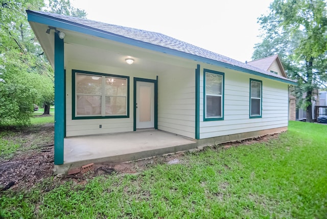 back of property featuring a porch and a lawn