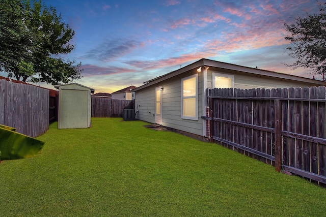 yard at dusk with a storage unit and central AC